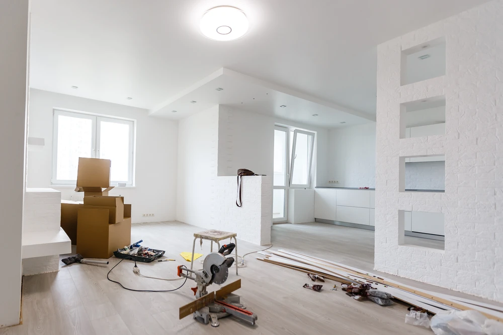 Homme en chemise à carreaux manipulant une scie sauteuse électrique bleue en extérieur
